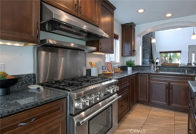 a kitchen with stainless steel appliances granite countertop a sink stove and cabinets
