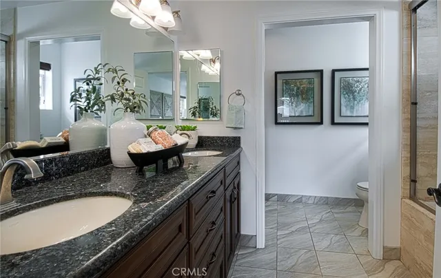 a spacious bathroom with a granite countertop sink a toilet and mirror