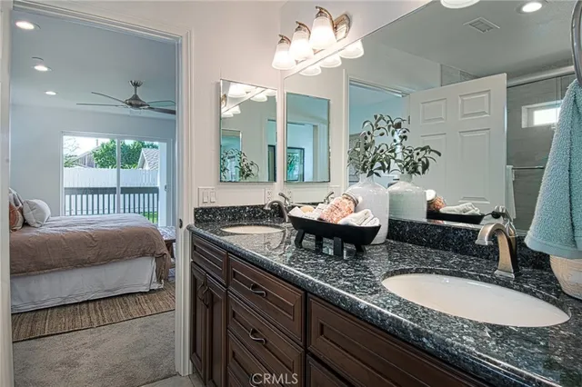 a bath room with a granite countertop sink and a mirror