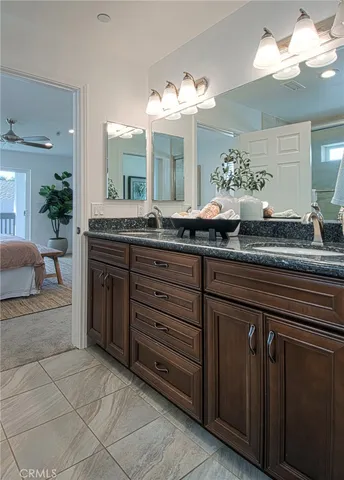 a bathroom with a granite countertop double vanity sink and a mirror