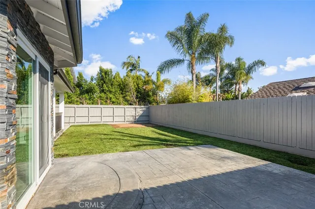 a view of a white house with a large windows and plants
