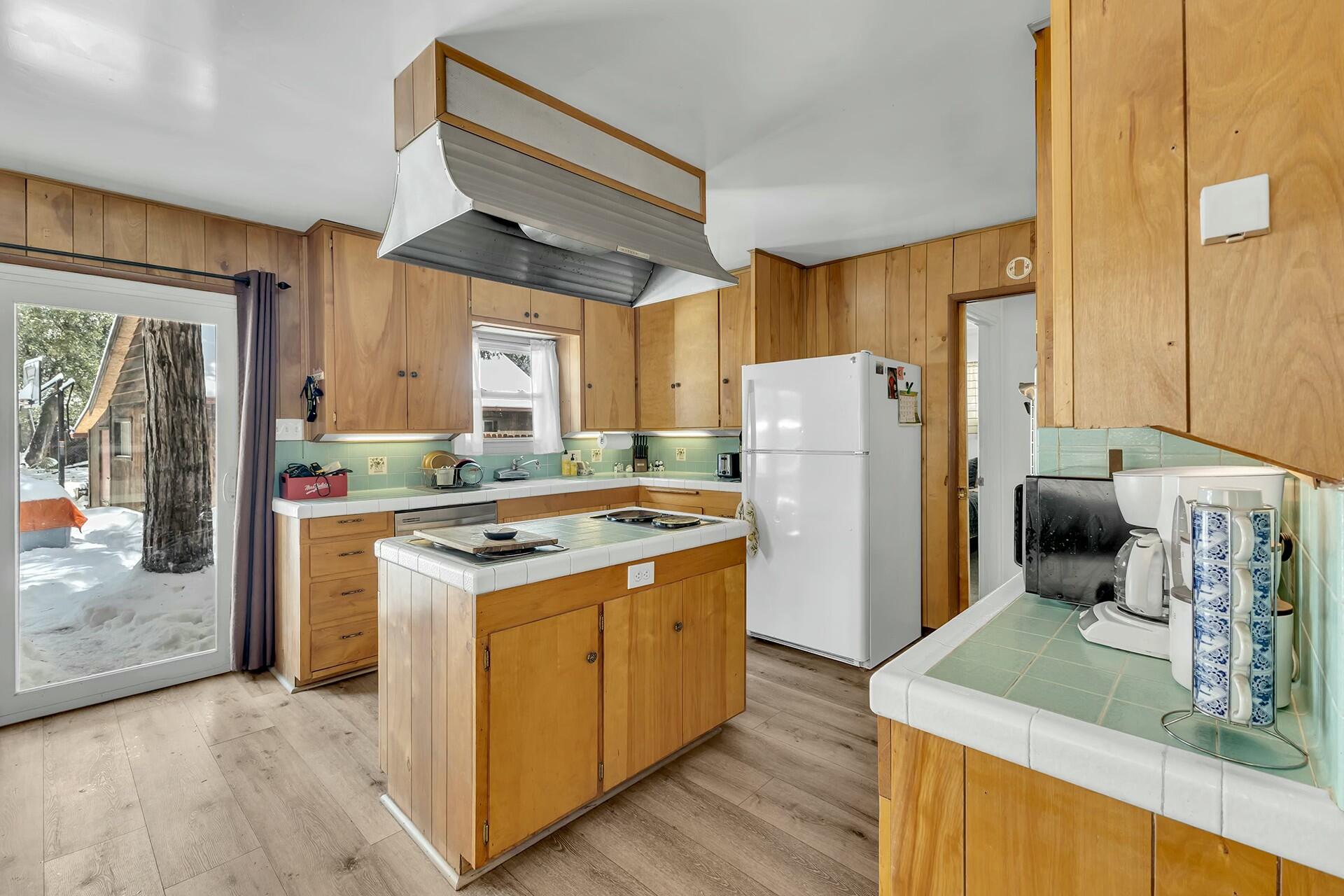 52660 Sylvan Way Idyllwild, CA 92549 - Photo 12 of 25 a kitchen with a refrigerator a stove top oven a counter space and a window