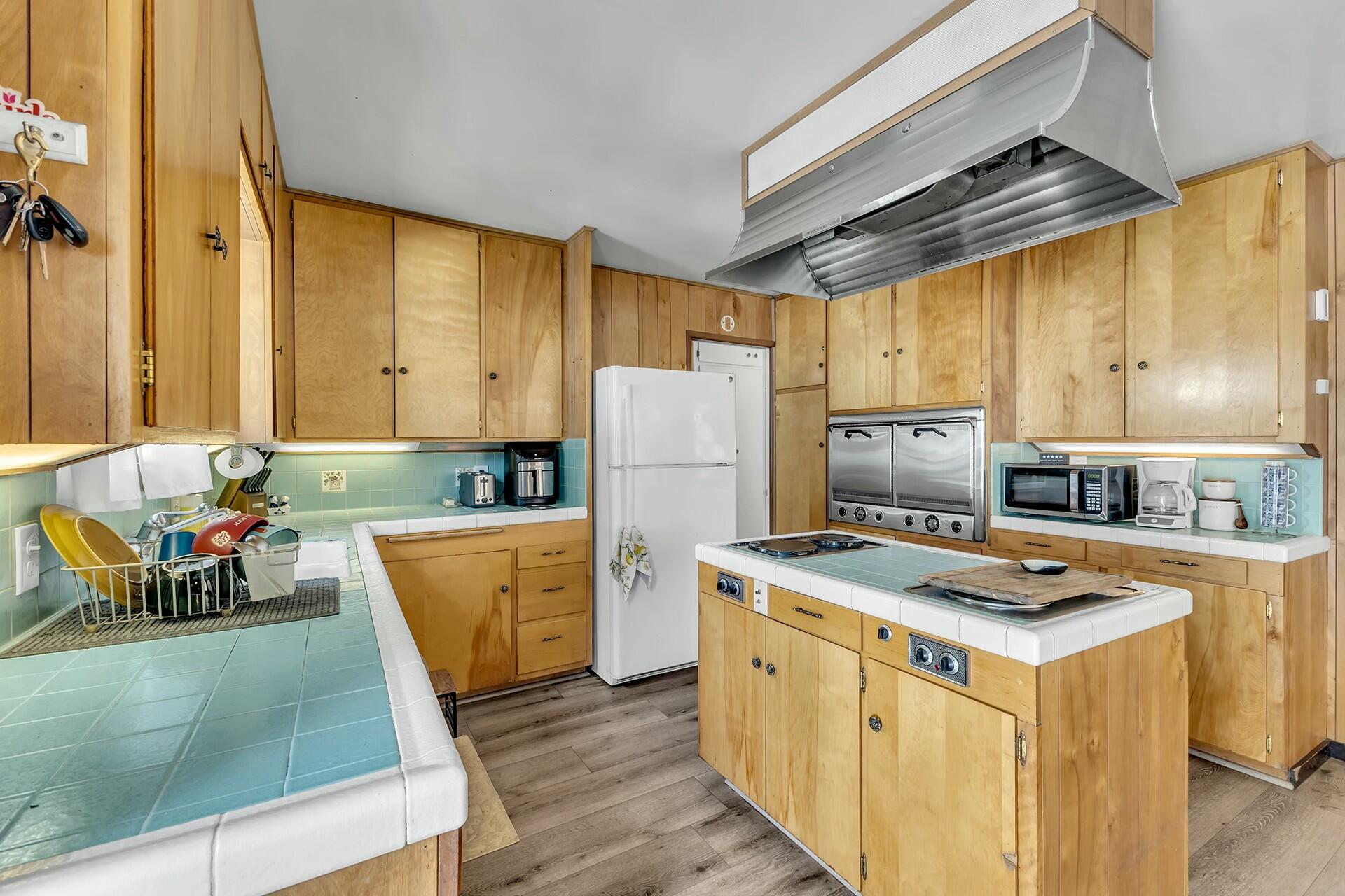 52660 Sylvan Way Idyllwild, CA 92549 - Photo 13 of 25 a kitchen with refrigerator cabinets and wooden floor