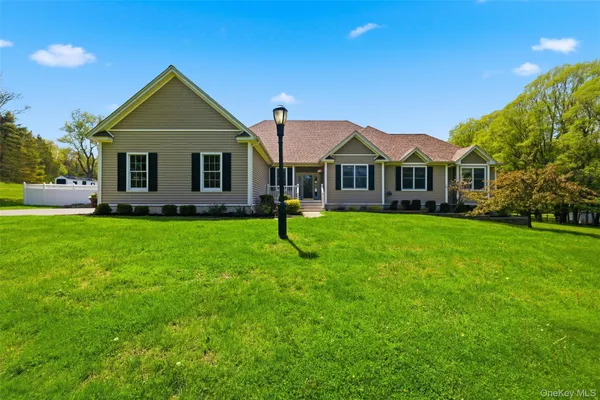 a front view of a house with a yard and trees