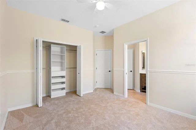 an empty room with closet and fan