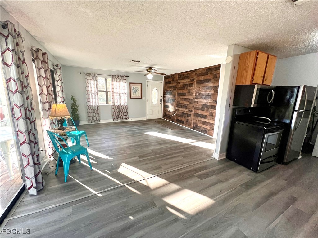 2002 Truman Avenue Alva, FL 33920 - Photo 17 of 30 a living room with furniture a flat screen tv and a floor to ceiling window