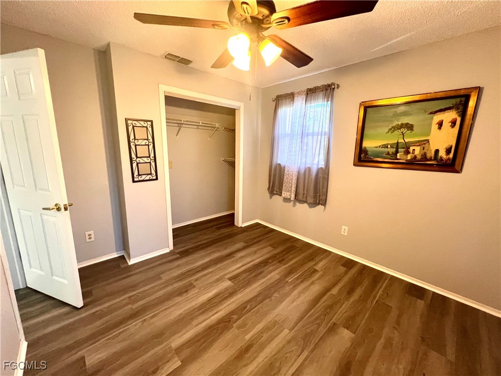 2002 Truman Avenue Alva, FL 33920 - Photo 21 of 30 a view of an empty room with wooden floor and a ceiling fan