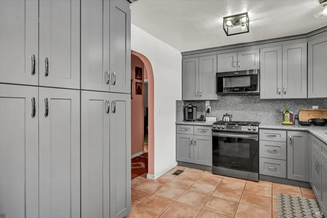 a kitchen with stainless steel appliances granite countertop a stove a sink and a refrigerator