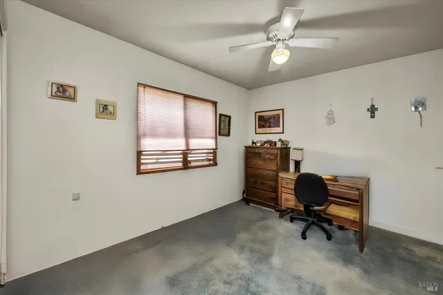 a view of a workspace with furniture and a window