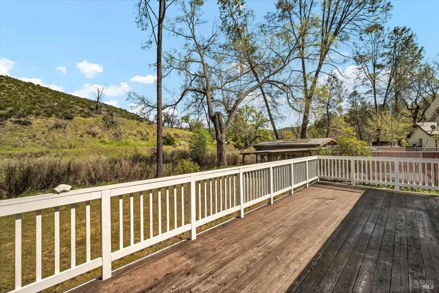 a view of balcony with wooden floor and fence