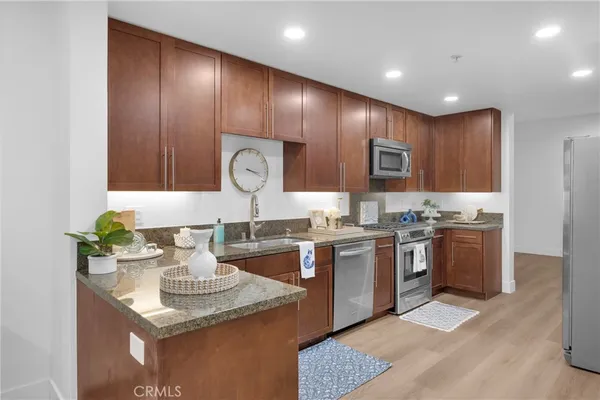 a kitchen with granite countertop a sink a stove and cabinets