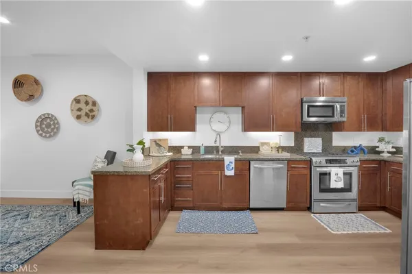 a living room with furniture a rug and kitchen view
