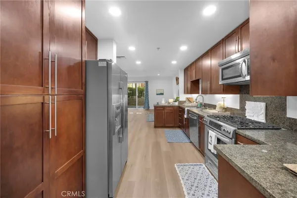 a kitchen with stainless steel appliances granite countertop a stove top oven a sink and dishwasher