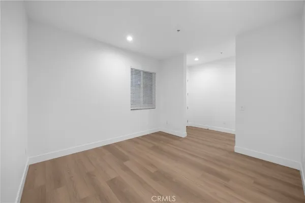 an empty room with a window and ceiling fan