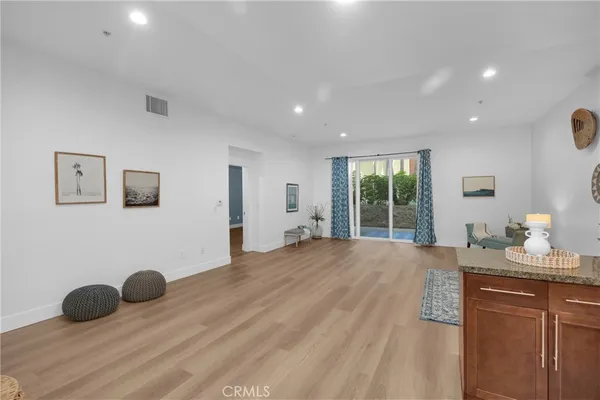 a kitchen with stainless steel appliances kitchen island granite countertop a refrigerator a sink a stove and wooden cabinets