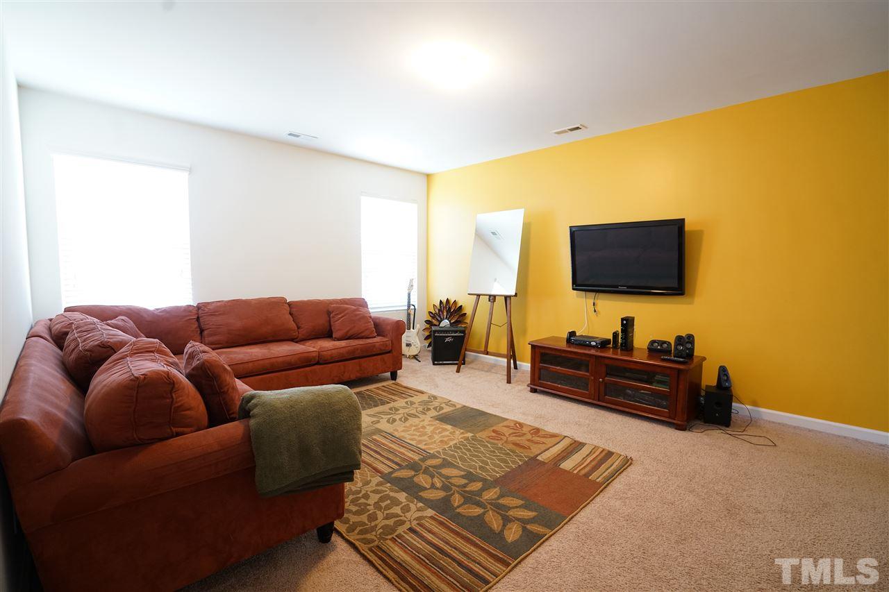 3716 Madeline Way Raleigh, NC 27610 - Photo 12 of 17 a living room with furniture and a flat screen tv
