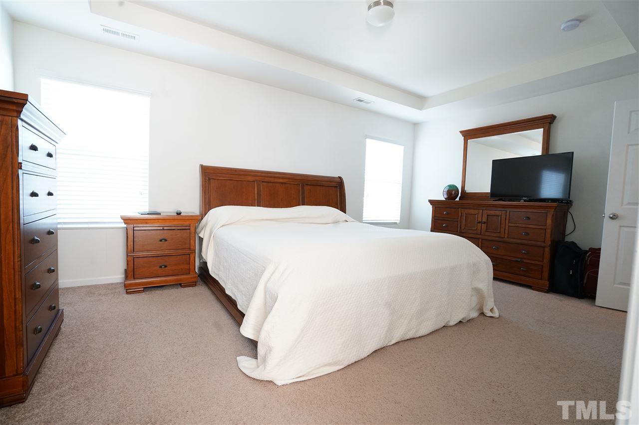 3716 Madeline Way Raleigh, NC 27610 - Photo 8 of 17 a bedroom with a bed and a flat screen tv
