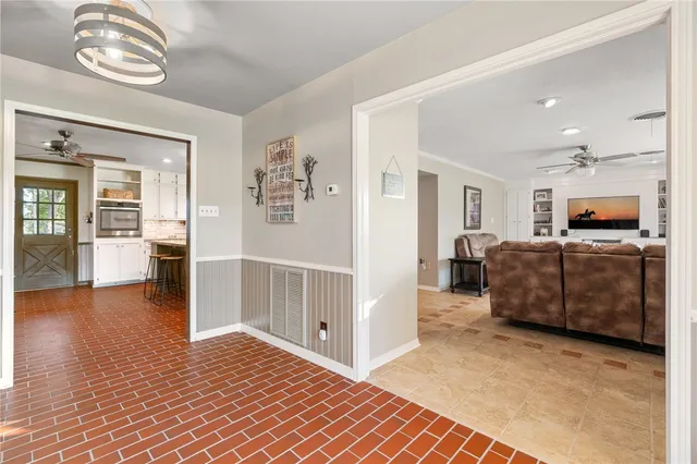a living room with furniture a flat screen tv and large window