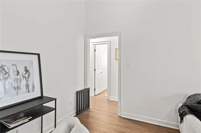 a view of a hallway with wooden floor and closet