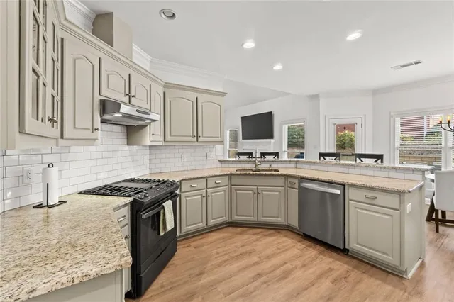 a kitchen with granite countertop a sink stove and refrigerator