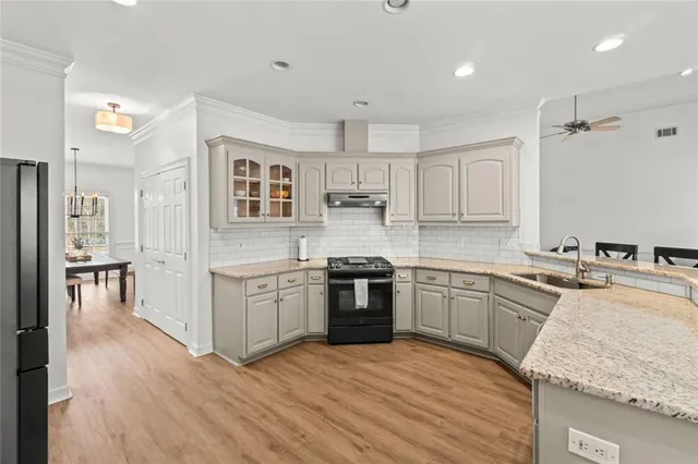 a kitchen with sink stove and refrigerator