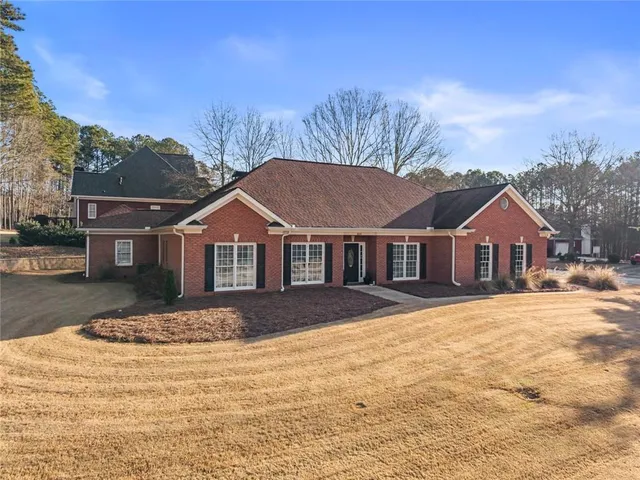 a front view of a house with a yard covered in snow