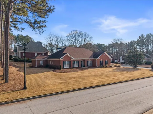 a view of a house with a big yard plants and large trees