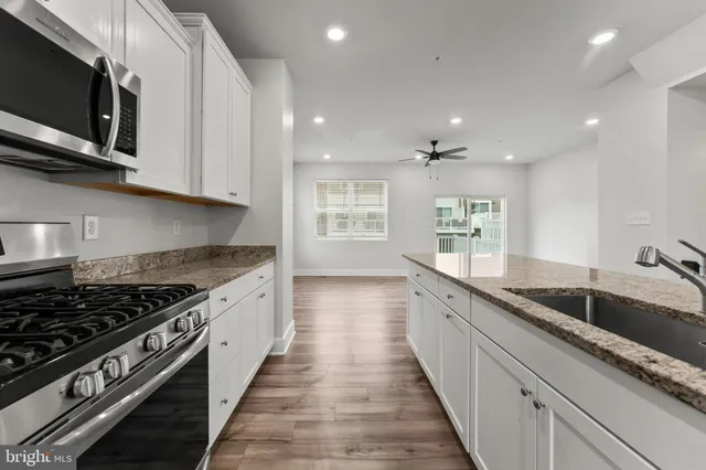 a large kitchen with stainless steel appliances granite countertop a sink and a stove