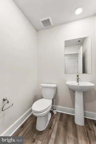 a bathroom with a sink toilet and a mirror
