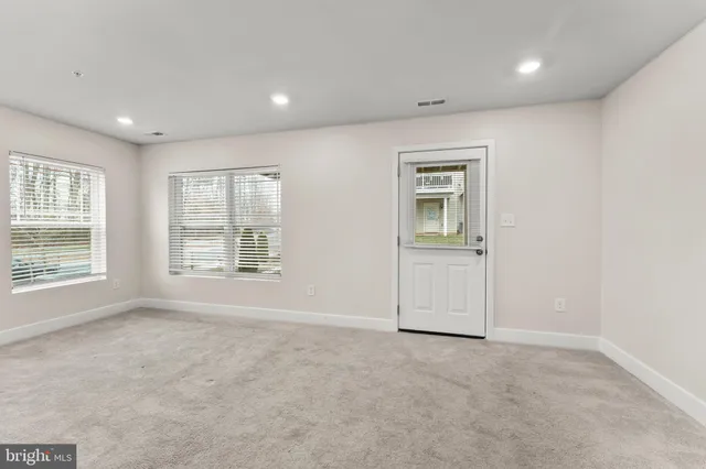 an empty room with windows and closet
