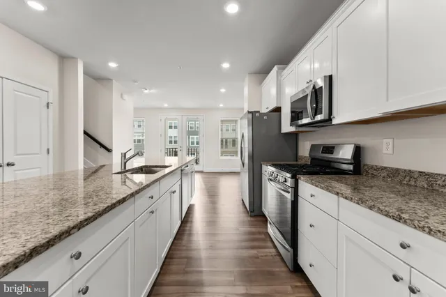 a large kitchen with stainless steel appliances granite countertop a lot of counter space