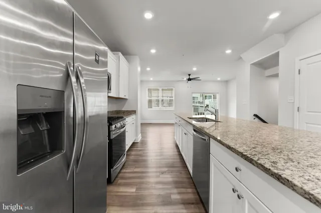 a kitchen with stainless steel appliances granite countertop a sink and refrigerator
