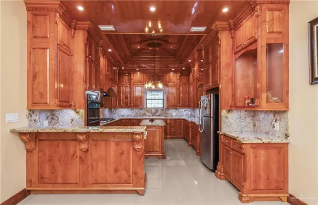 a kitchen with stainless steel appliances granite countertop a sink and wooden cabinets