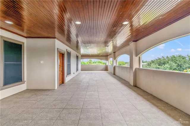 a view of empty room with window and ceiling fan