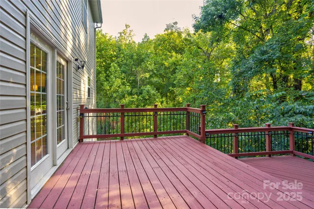 a view of backyard with wooden fence and large trees