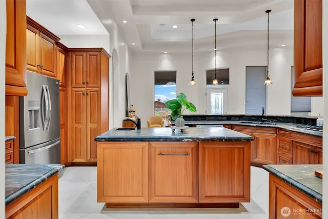 a kitchen with stainless steel appliances granite countertop a sink a stove and a refrigerator