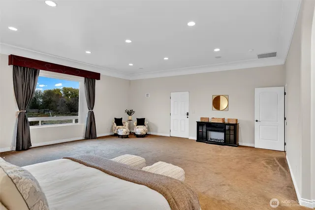 a large bedroom with a bed and a large window