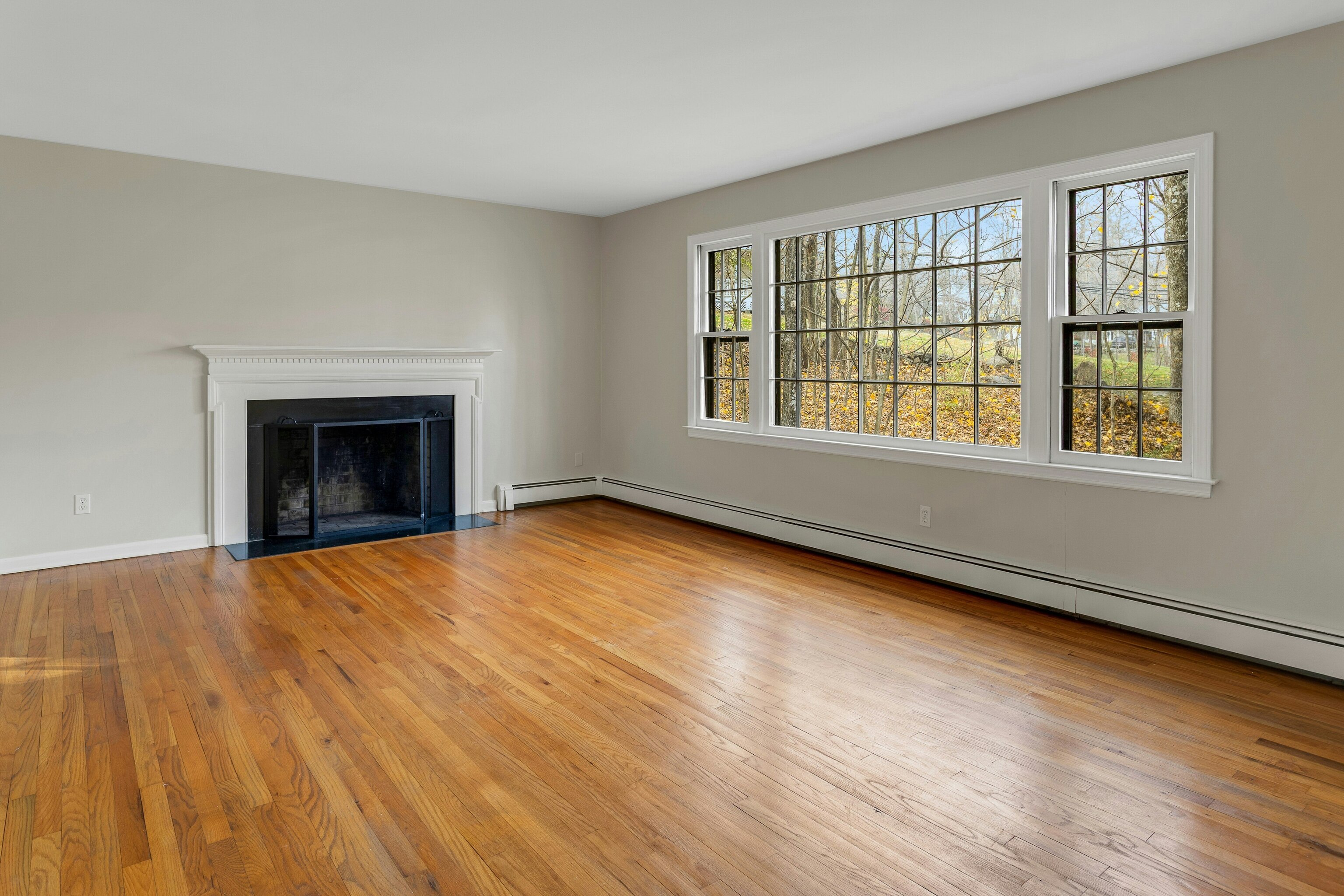64 Jelliff Mill Road New Canaan, CT 06840 - Photo 4 of 24 an empty room with wooden floor fireplace and windows