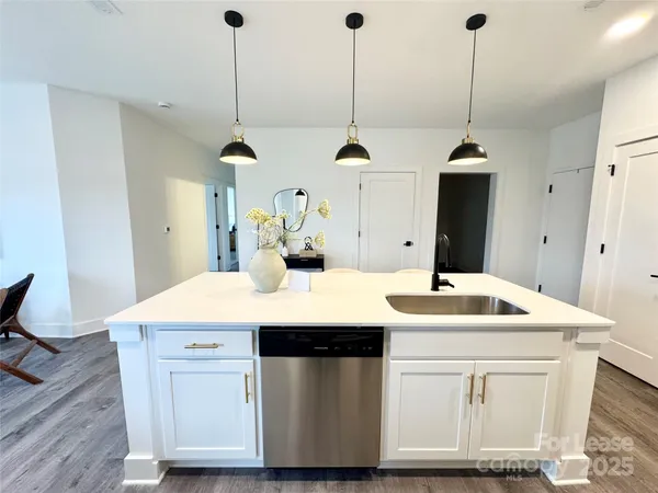 a kitchen with a sink a island a stove and wooden floor