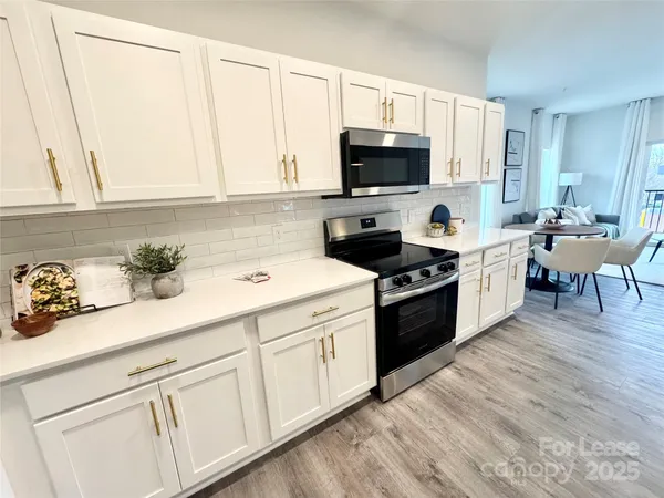 a kitchen with granite countertop white cabinets and white appliances
