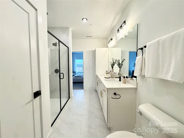 a bathroom with a sink toilet mirror and shower