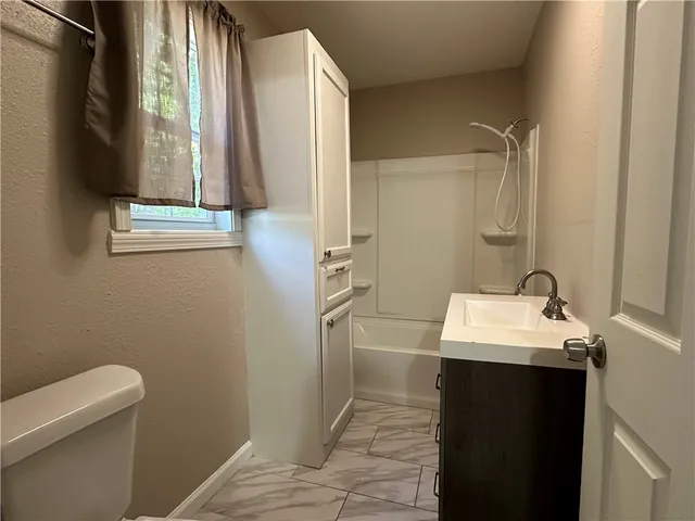 a bathroom with a sink a toilet and a mirror