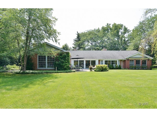 1575 Tower Road Winnetka, IL 60093 - Photo 18 of 21 a front view of a house with a garden