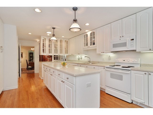 1575 Tower Road Winnetka, IL 60093 - Photo 5 of 21 a kitchen with kitchen island granite countertop a sink appliances cabinets and a counter top space