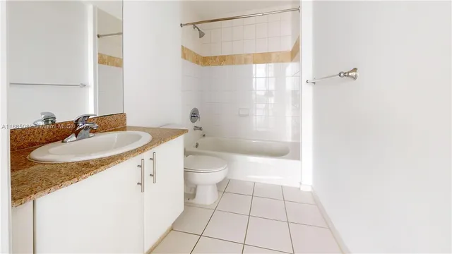 a bathroom with a granite countertop sink a toilet and shower