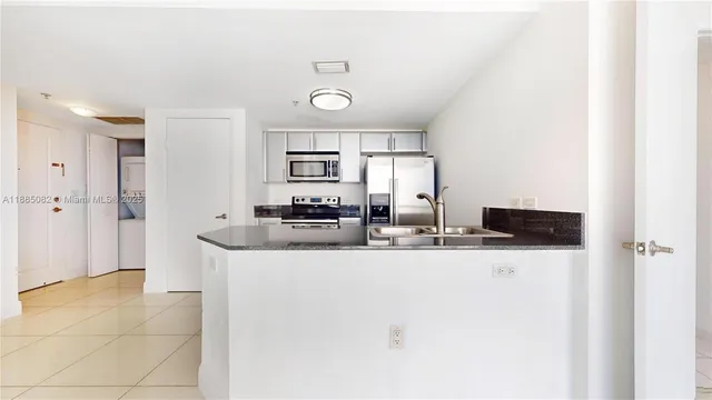 a kitchen with stainless steel appliances a sink and a refrigerator