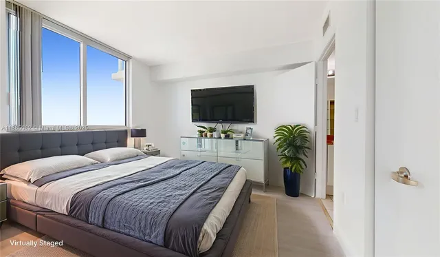 a bedroom with a bed and a flat screen tv