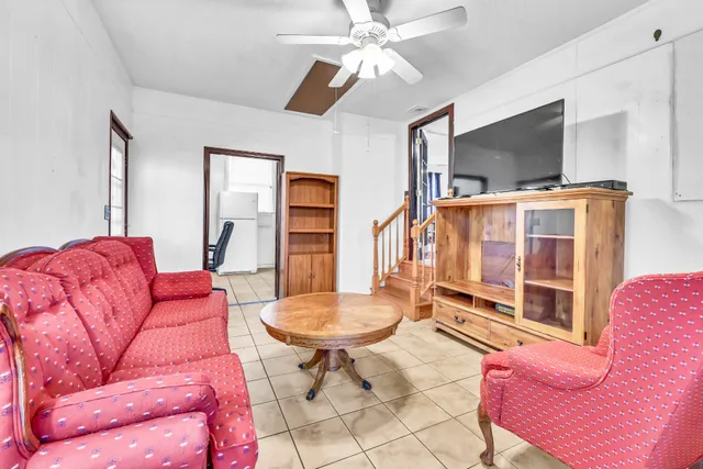 a living room with furniture a flat screen tv and a window