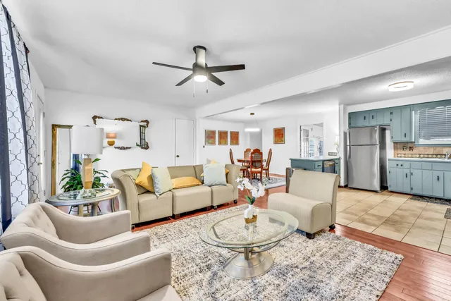 a living room with furniture kitchen view and a table