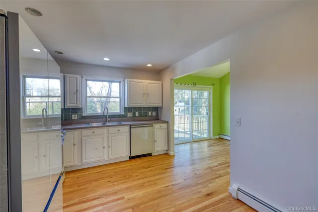 a large kitchen with wooden floor and natural light